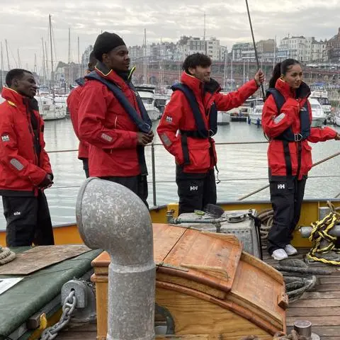 A group of young people wearing life jackets on a boat