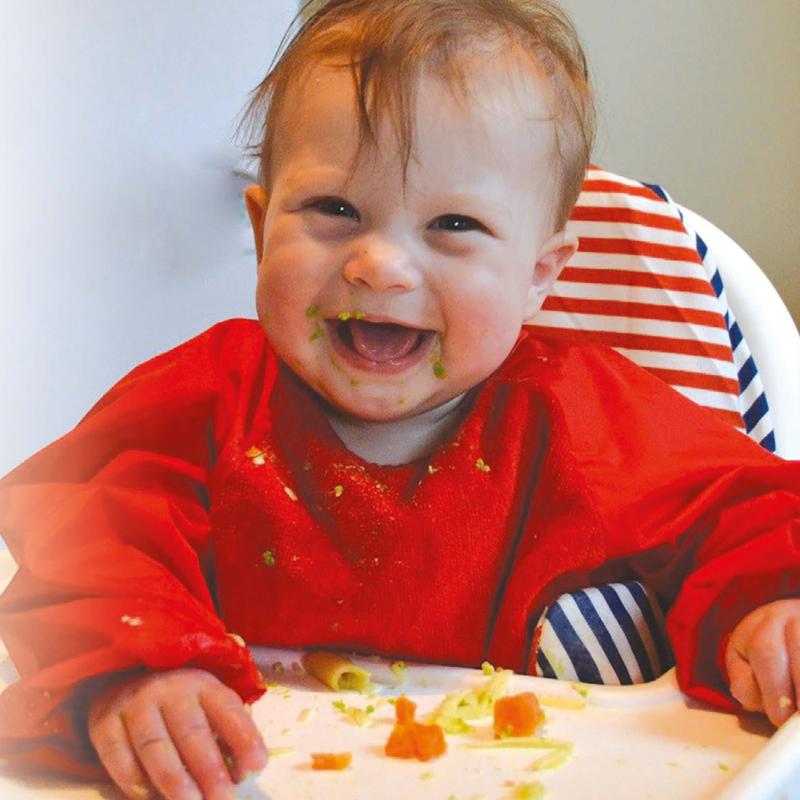 baby eating food on high chair