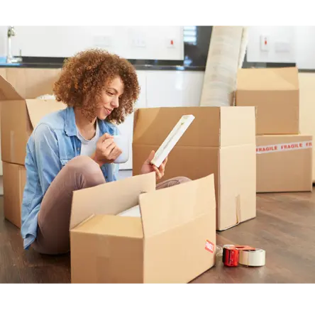 Young person moving home with boxes around her.