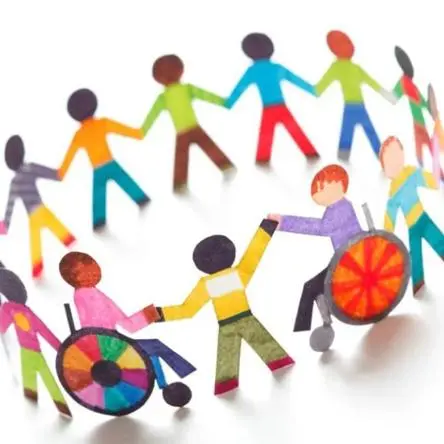 children stood and in wheelchairs holding hands