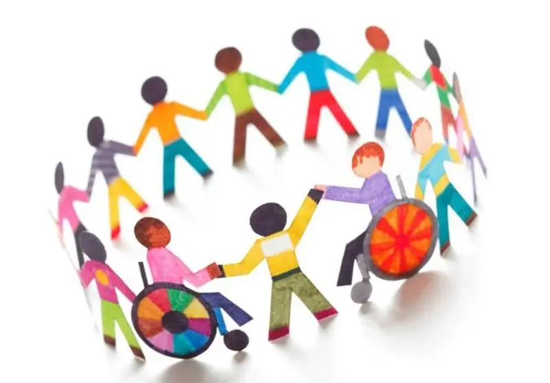 children stood and in wheelchairs holding hands