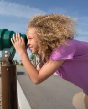 young girl looking through telescope