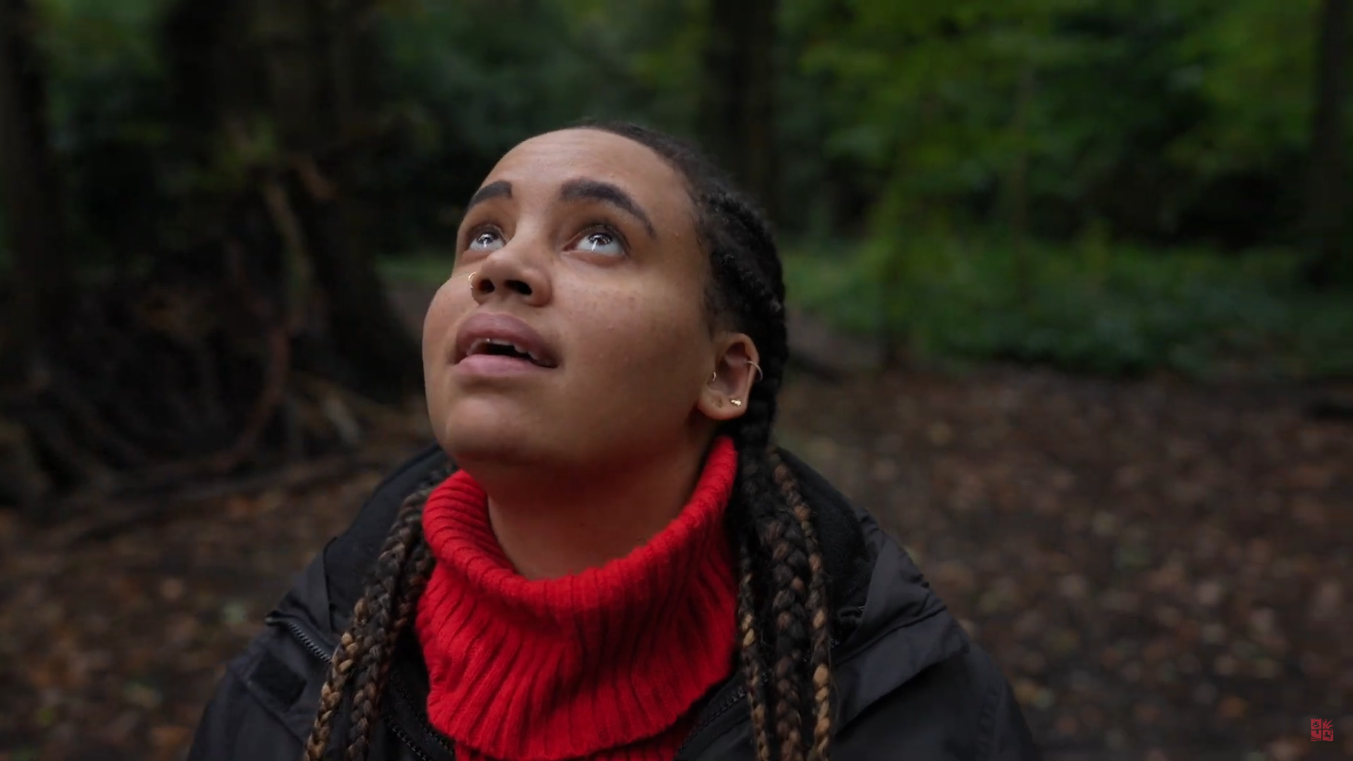 Girl in the woods looking upwards